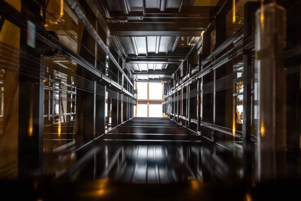 The passenger lift shaft seen from the glass cabin, a glazed roof at the top.